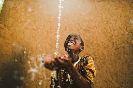 A young child happily catching water.