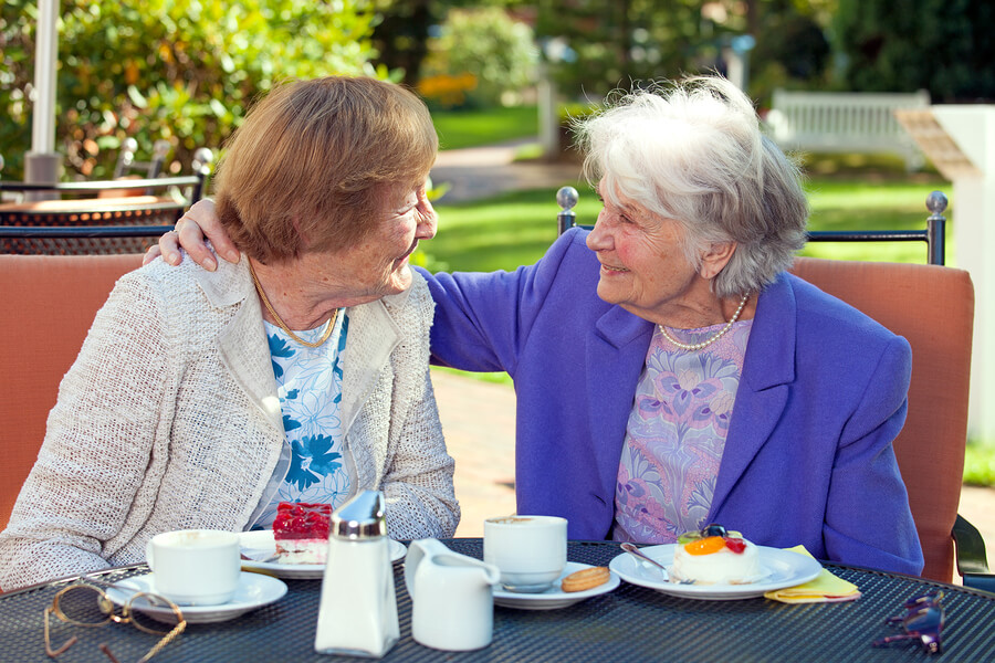 two senior women having their tea in the yard
