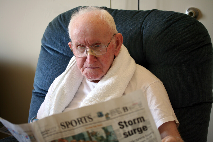 a senior busily reading a newspaper