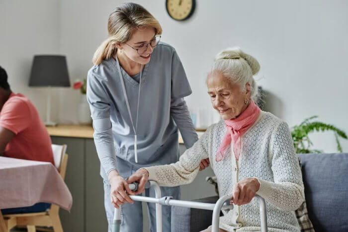 young caregiver assisting senior with a senior living assisted living services