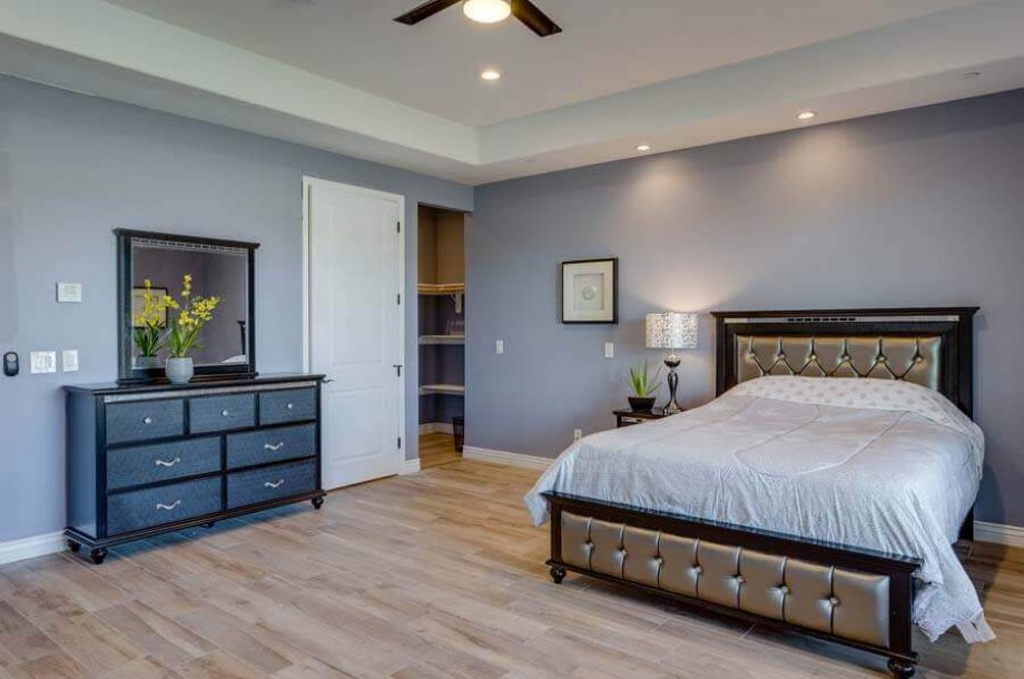 A bedroom with a bed and dresser